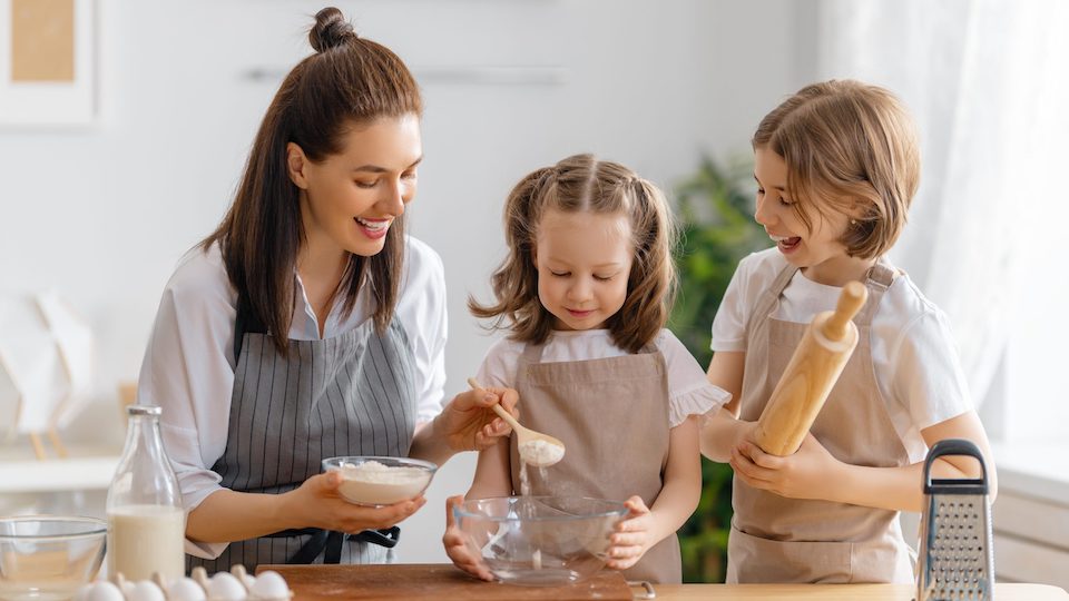 Woman and two children cook and bake in a kitchen