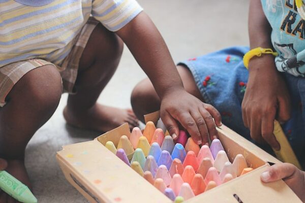 two children play with coloured chalk